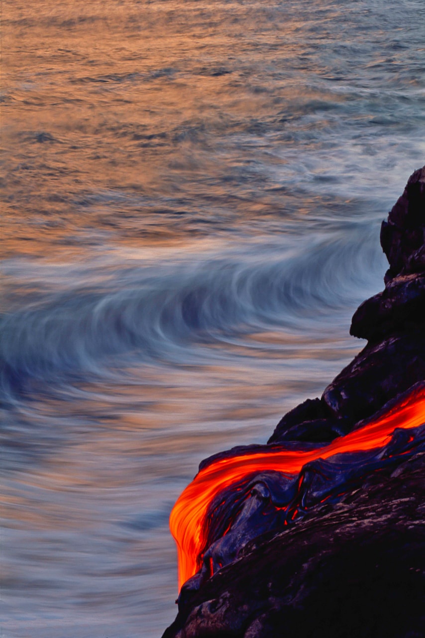 Waves crash behind a lava flow on the Big Island of Hawaii in this photo by Brad Lewis. Kilauea is the most active volcano on Earth.