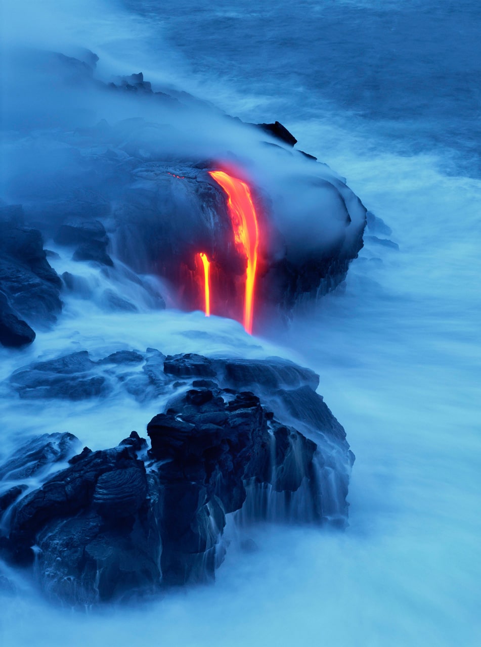 Lava flows into the sea off of the Big Island of Hawaii in this photo by Brad Lewis. Kilauea is the most active volcano on Earth.