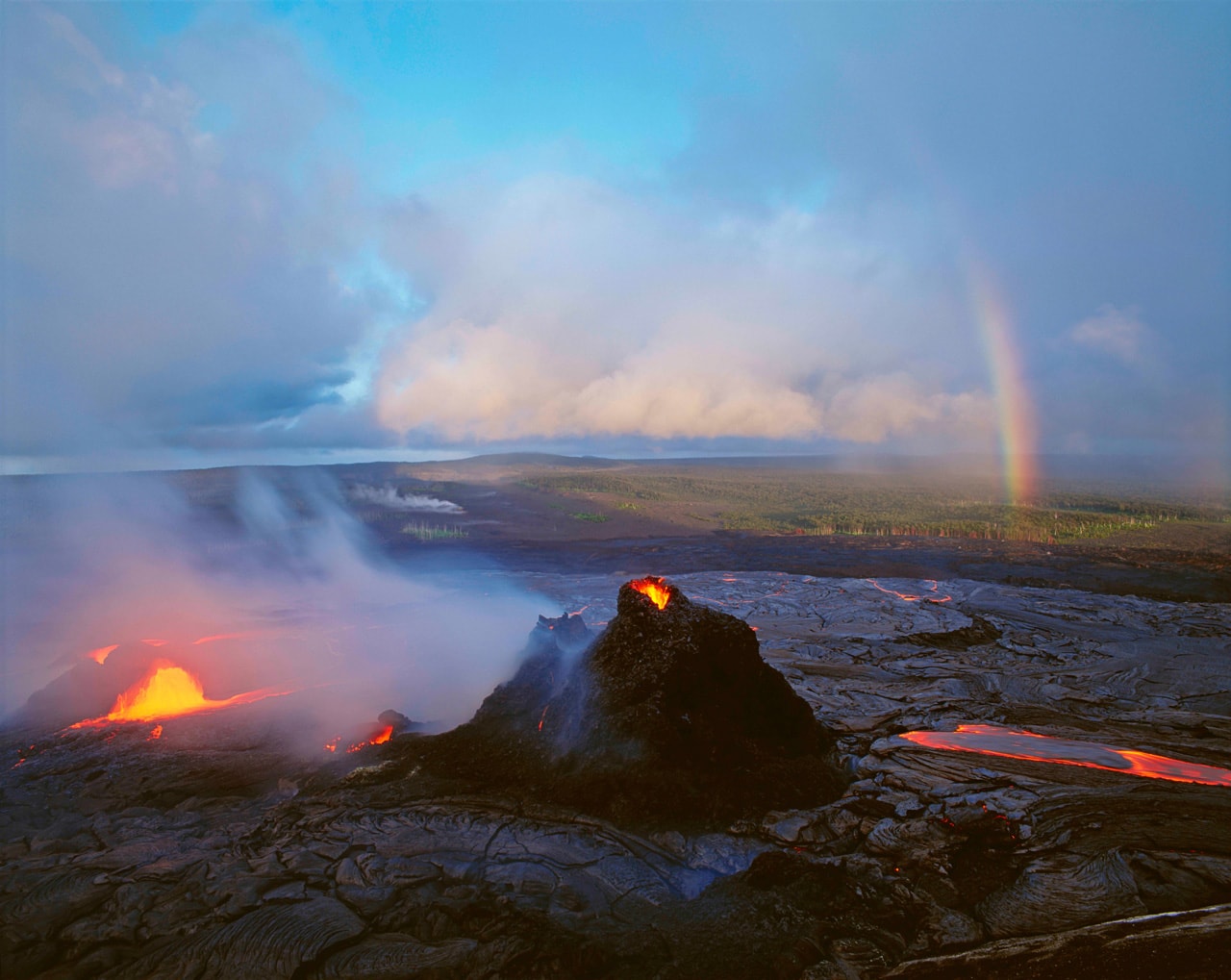 A rainbow appears above the Kilauea Volcano, the most active on earth, in this photo by Brad Lewis.