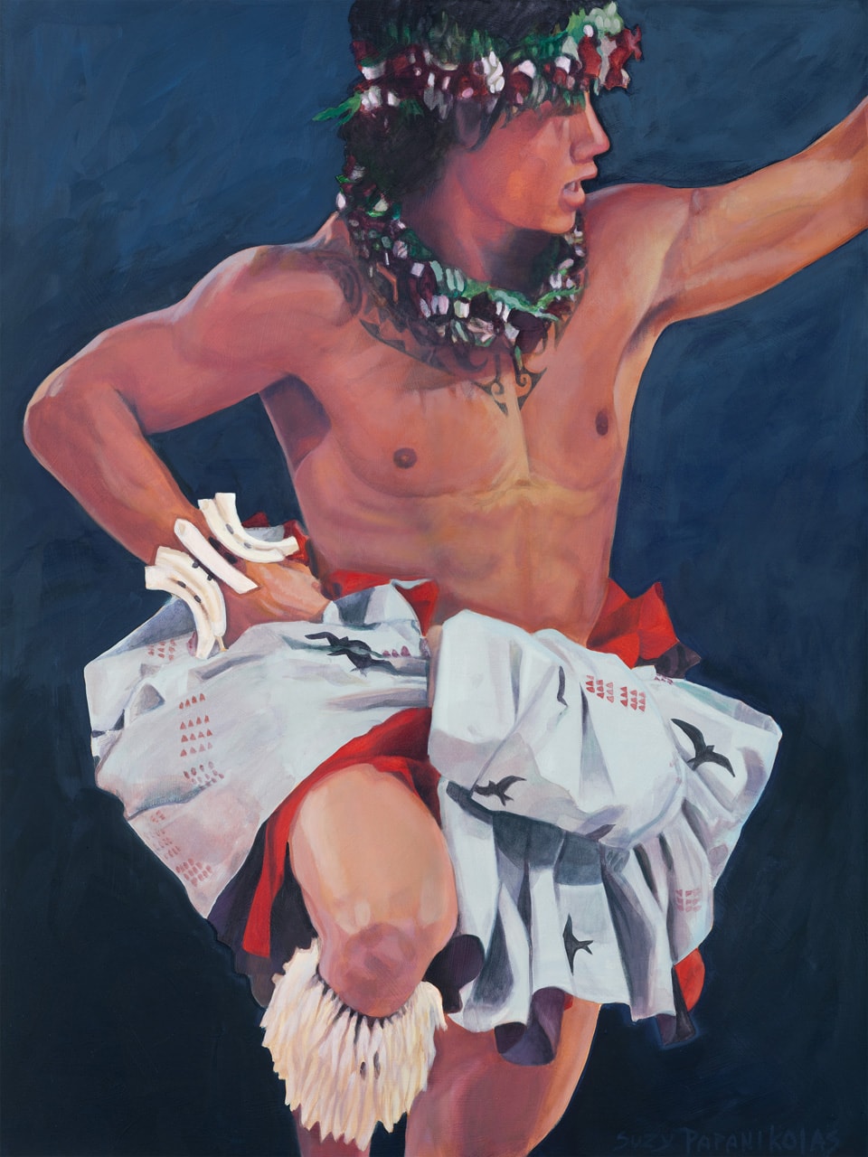 A male hula dancer in motion with one knee up and one hand towards the sky, wearing red and while hula attire