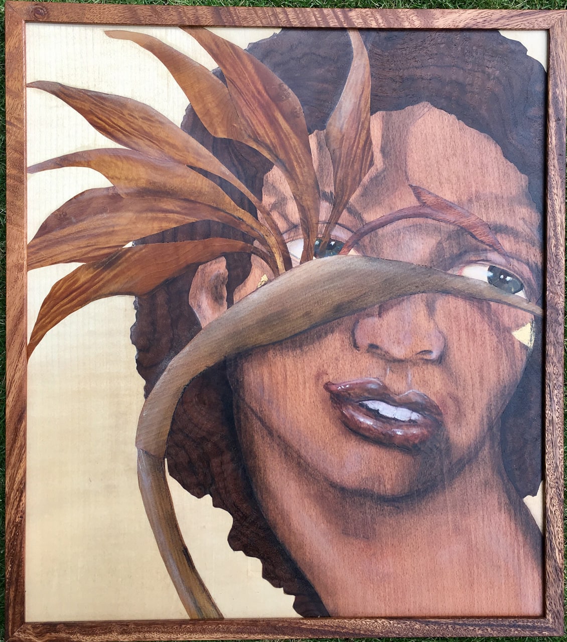 See by Juli Morsella marquetry depicting a man's face behind a bird of paradise plant