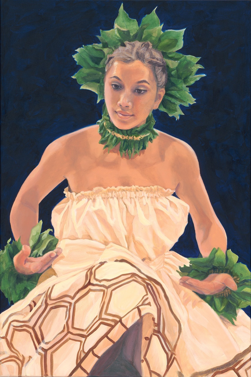 A female hula dancer in motion, wearing brown hula attire and ti leaf accessories