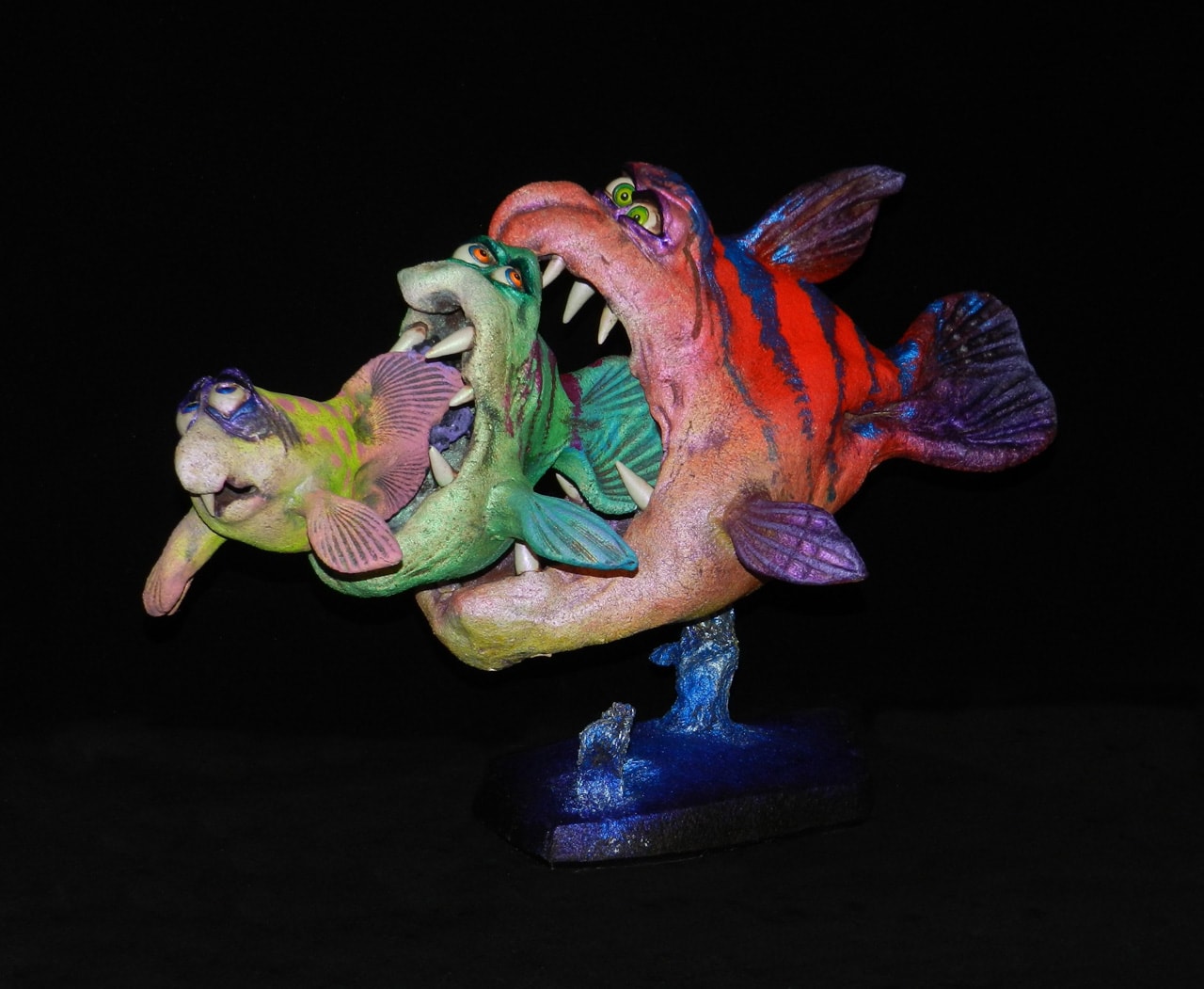 Seafood by Steven Lee Smeltzer cartoonish whimsical clay sculpture of three fish eating each other