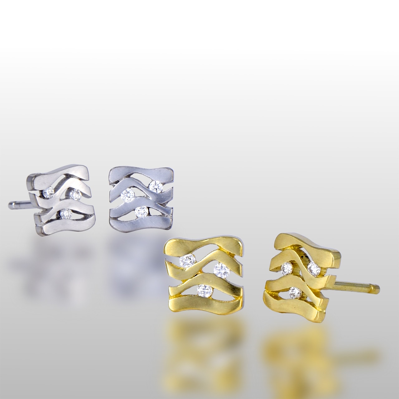 Two pairs of stud earrings. Square shaped made of white and yellow gold. Floating diamonds in the middle