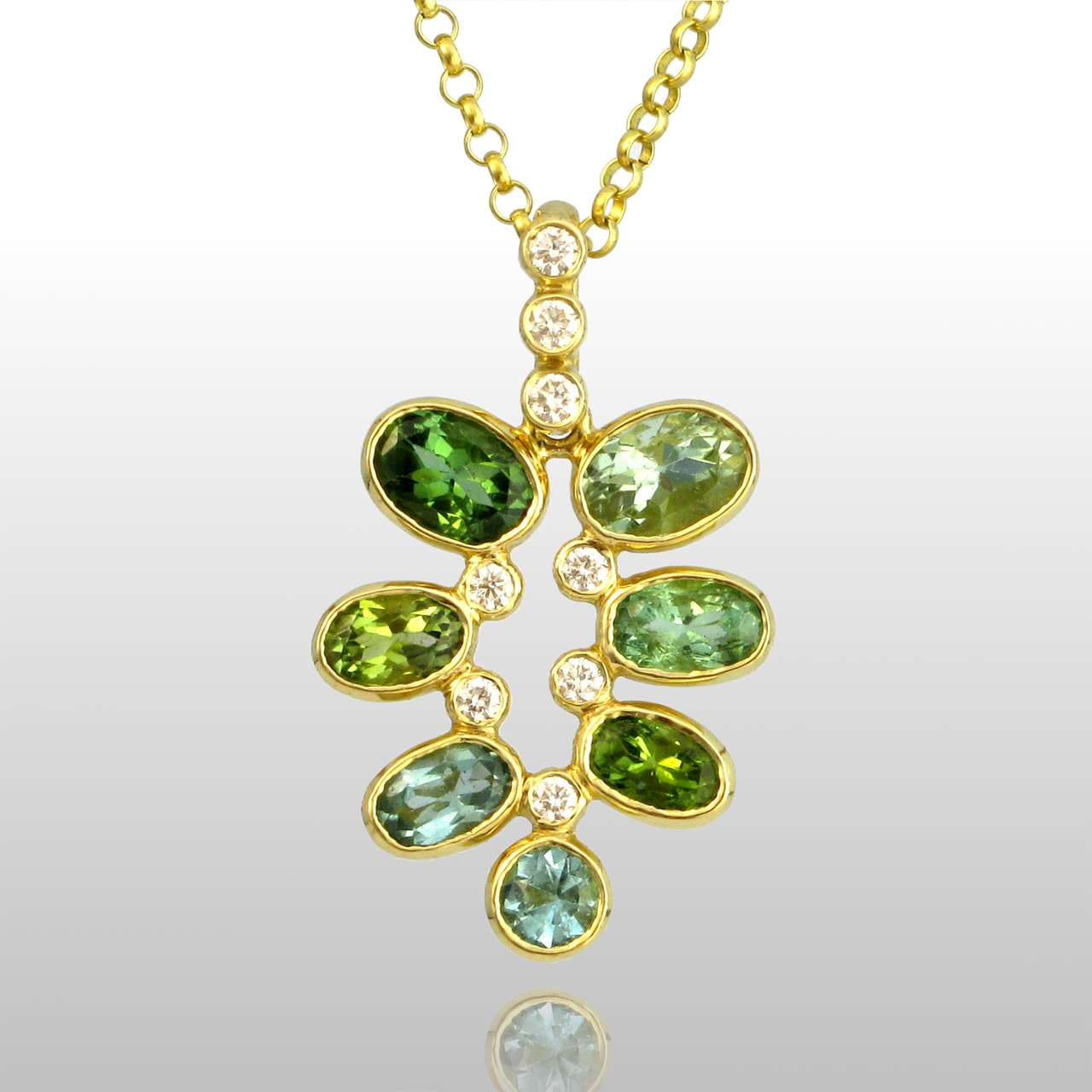 Gold pendant with 7 green stones, all different shades of green. And diamonds.