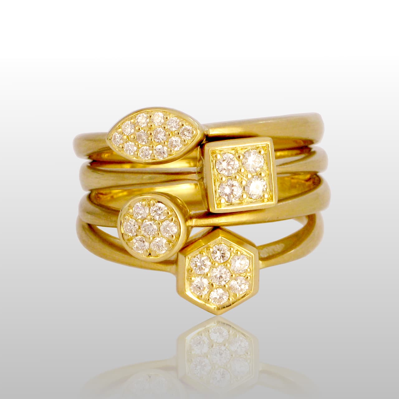 5 gold rings with various shapes and small diamonds in the center of each