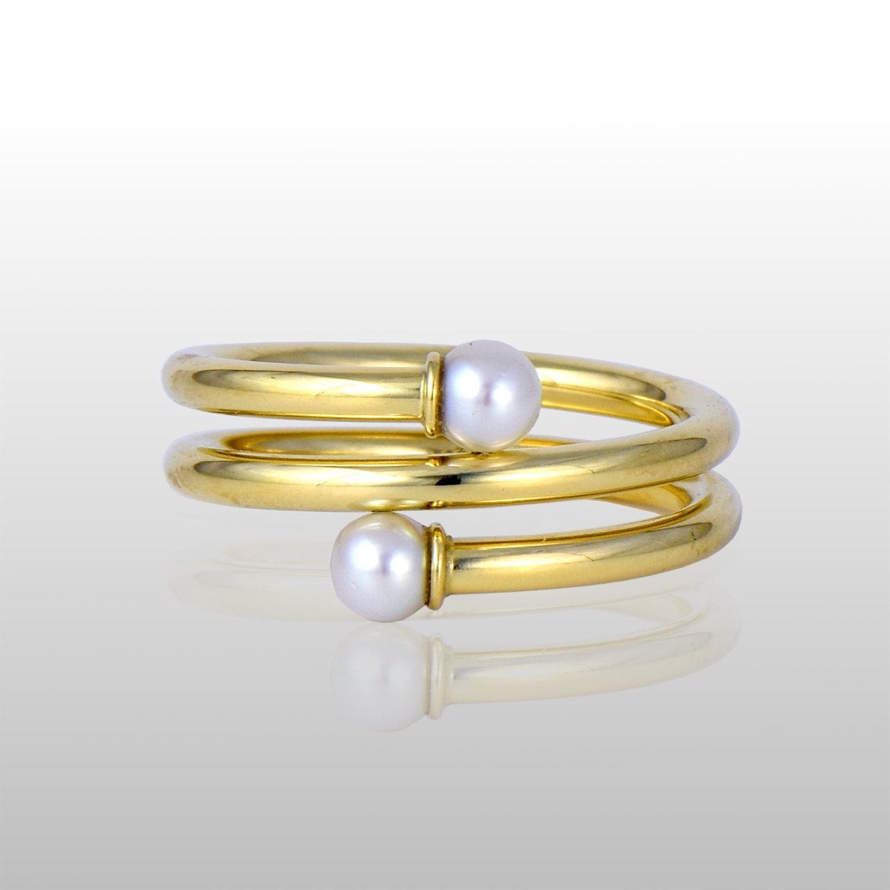 Gold spiral ring with with two pearls on each end.