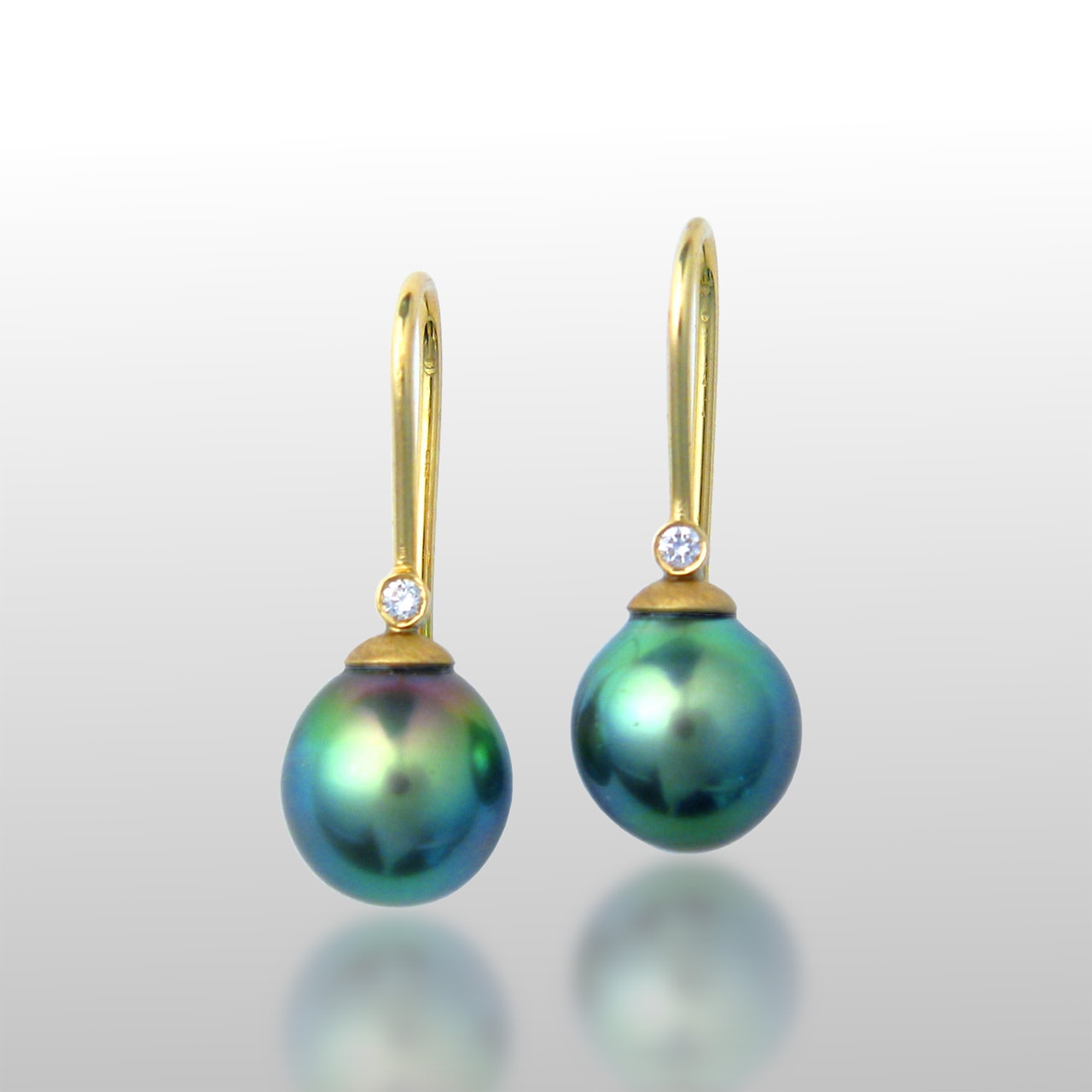 Tahitian Pearl earrings with a diamond on each side. Ear wires are made of 18k gold. Dangle earrings