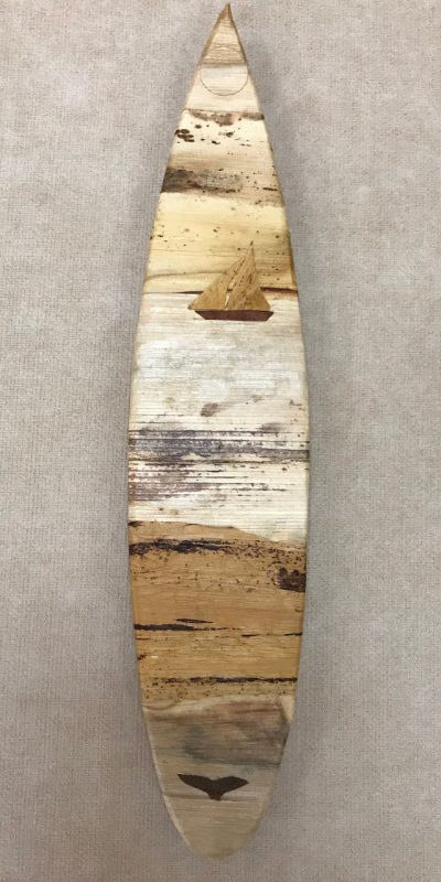 Small surfboard wall hanging from the mind of Baz Cumberbatch. He carves the background from wood, then adds layers of natural fibers by hand