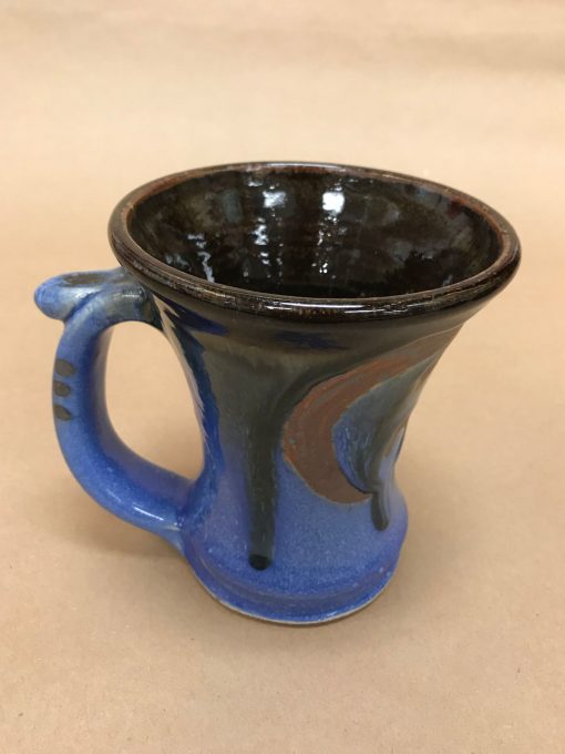 large ceramic mug with a wide rim and thumb rest. Brown, light and dark blue colors.