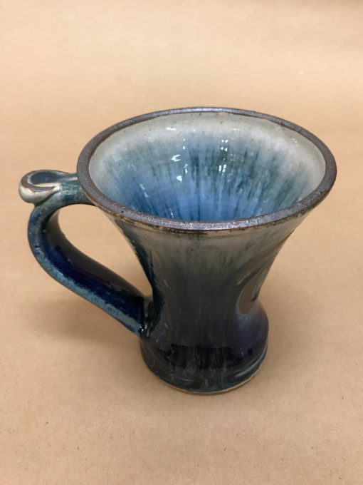 a large ceramic mug with a wide rim made up of mostly blue hues