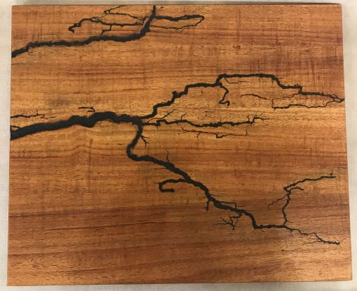 a original wall hanging made of Hawaiian Koa wood. Socked with electricity to form an organic design. Outline of electrical waves is black, against the wood grains.