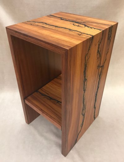 a stand, or shelf made of Hawaiian Koa and Wenge wood. Shocked with electricity to form an organic design. Side View