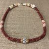 Ni’ihau lei, 19″ 4-tie Poepoe with Pikake Momi. Created by master artisan Kanani Puo.